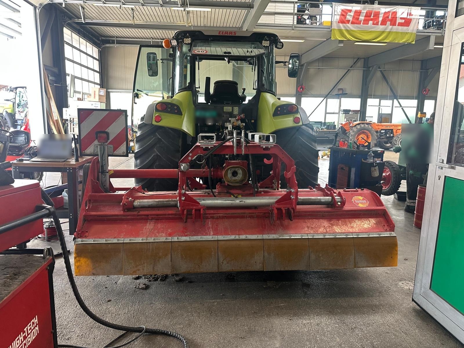 Trituradora de martillos montada en un tractor en un taller agrícola, lista para el equilibrado